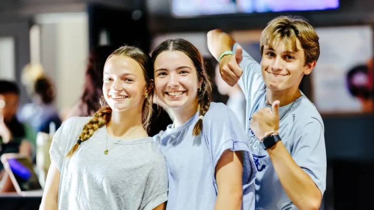 Three smiling students at TBC Students breakfast in Lake Charles.