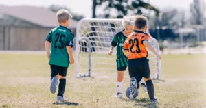 Boys in team jerseys chasing the ball at Upward Soccer, Trinity Baptist Church.