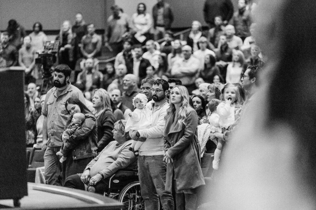 Families with infants standing before the congregation during a Parent Commitment ceremony at Trinity Baptist Church.