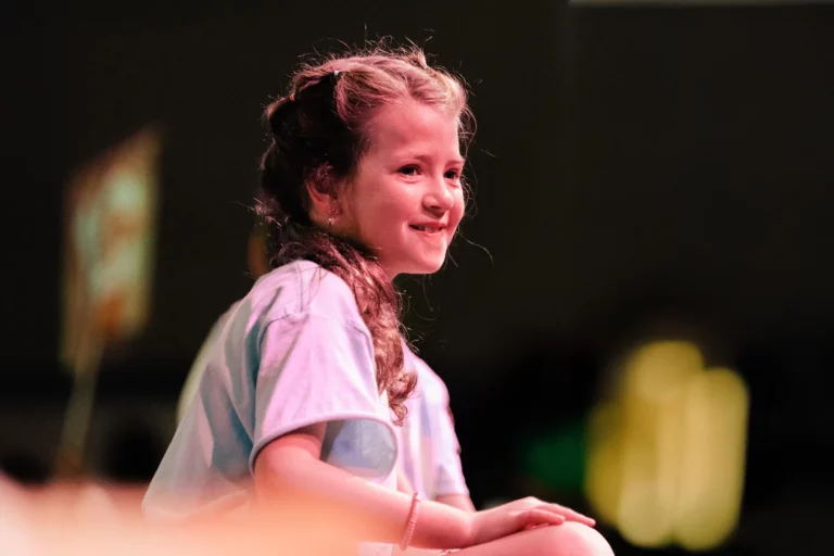 Smiling young girl on stage during VBS at Trinity Baptist Church.