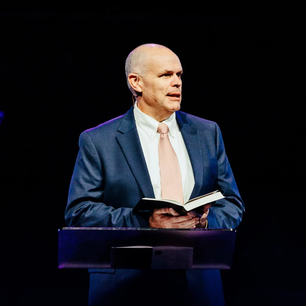 Dr. David Rose preaching from the pulpit during Easter sermon at Trinity Baptist Church