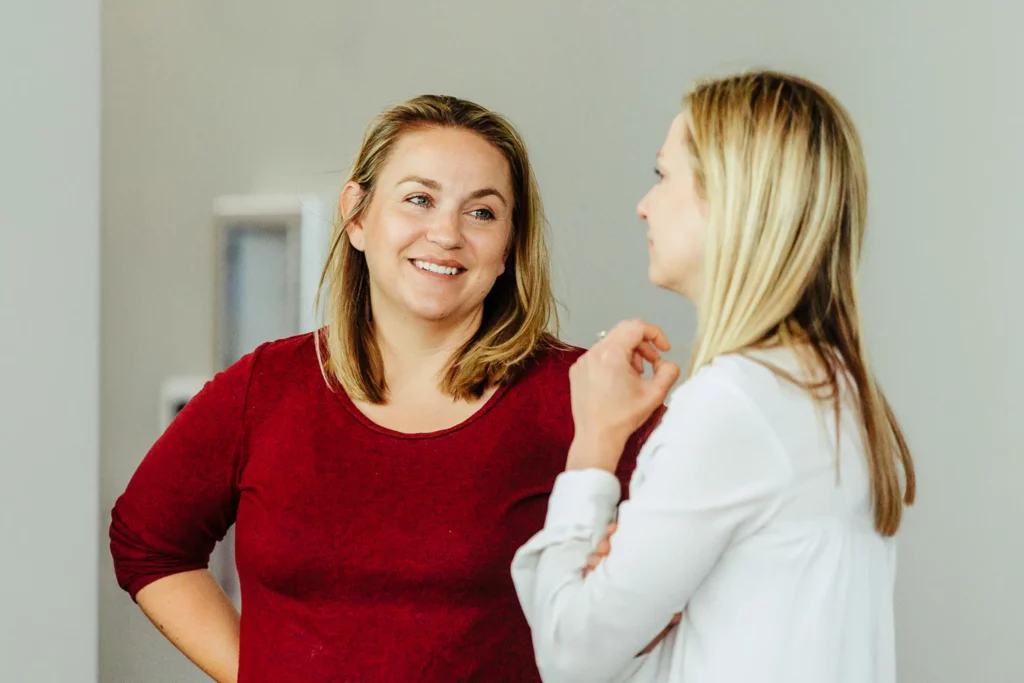 Two women smiling and chatting at a Trinity Baptist Church small group gathering.
