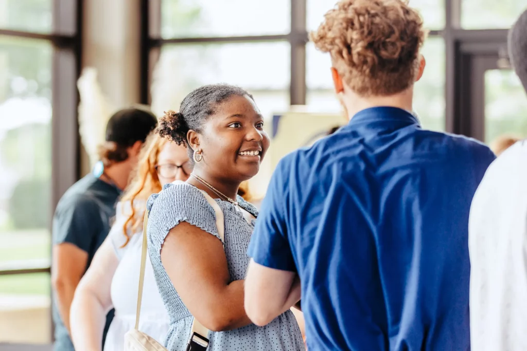 Smiling greeter welcoming a guest in the lobby at Trinity Baptist Church.