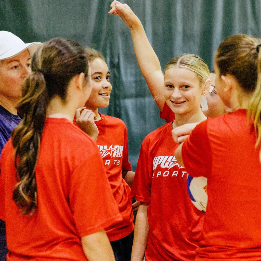 Girls in red Upward Sports shirts gathered with a coach at the Trinity Center.