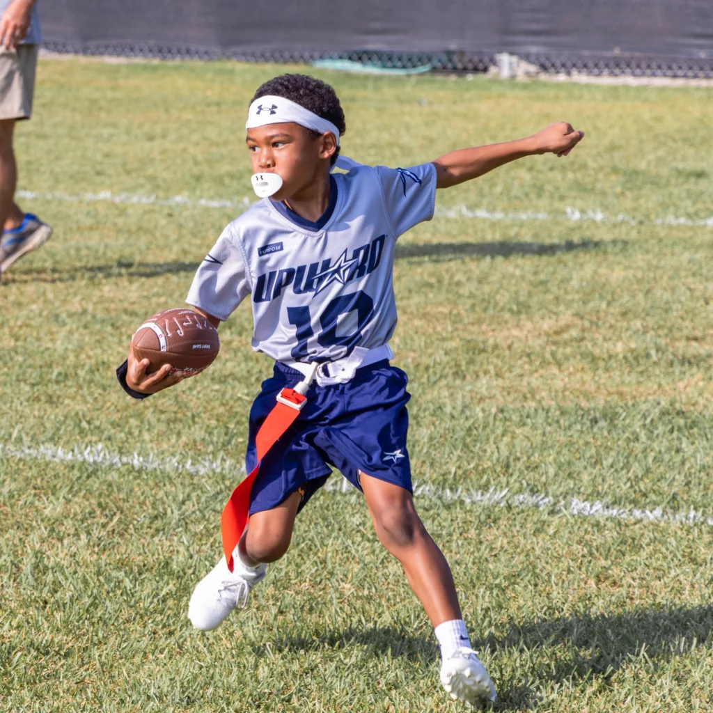 Kids running plays at Trinity Baptist’s Flag Football Clinic—learning skills and teamwork.