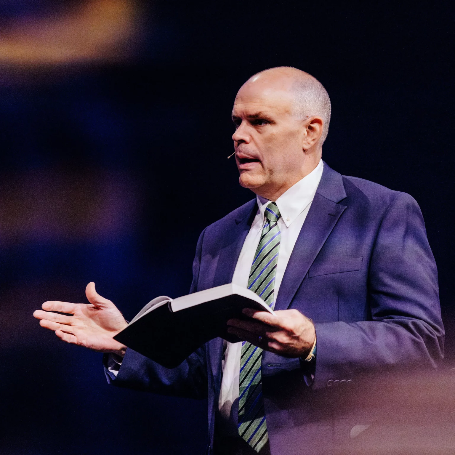 Dr. David Rose preaching at Trinity Baptist Church with Bible in hand.