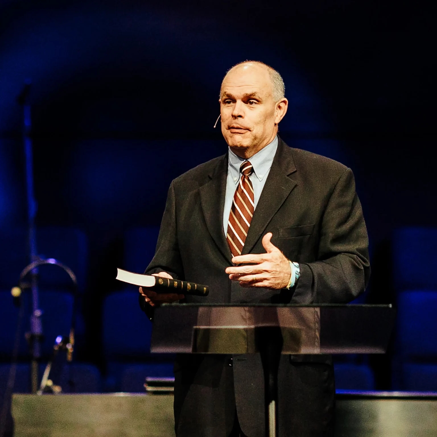 Pastor preaching with Bible in hand during sermon on the value of preborn lives.
