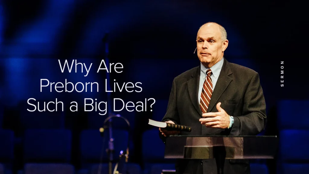 Pastor David Rose holding a Bible while preaching on the value of preborn lives at Trinity Baptist Church.
