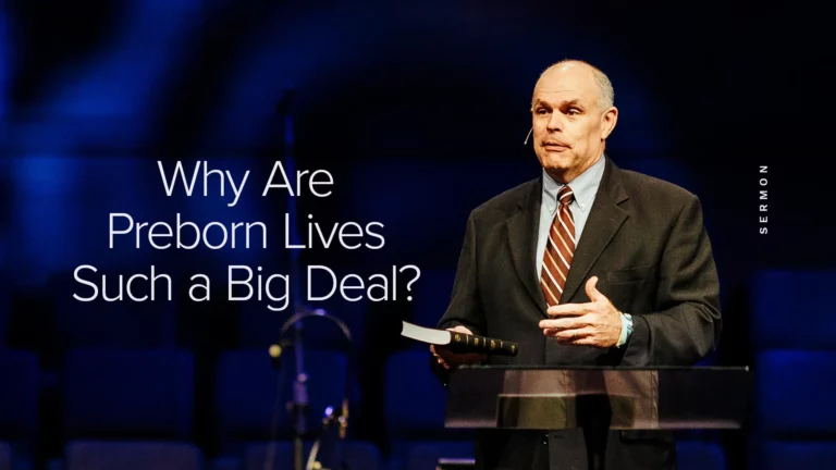 Pastor David Rose holding a Bible while preaching on the value of preborn lives at Trinity Baptist Church.