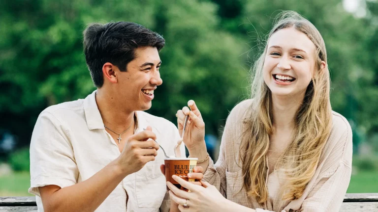 Smiling couple sharing ice cream outdoors on a date