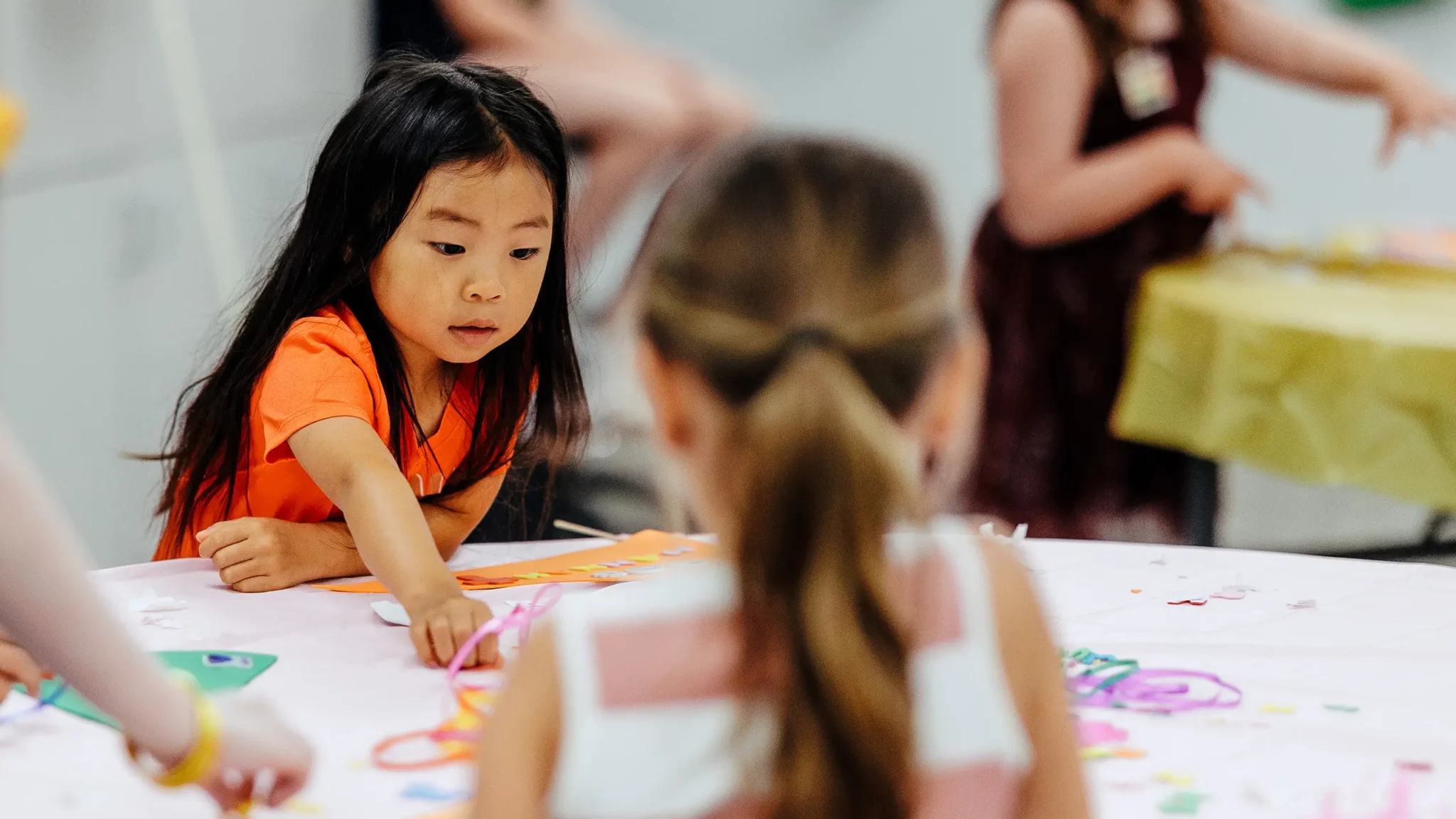 Child engaged in colorful craft activity during Trinity Kids class.