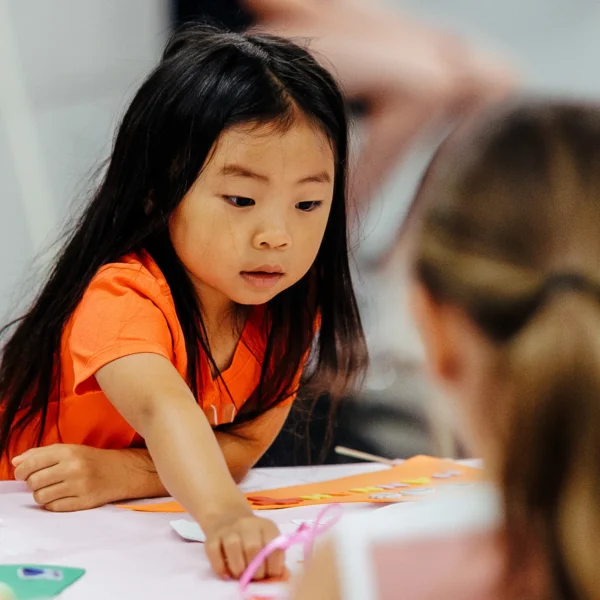 Trinity Kids ministry logo over image of child doing crafts.