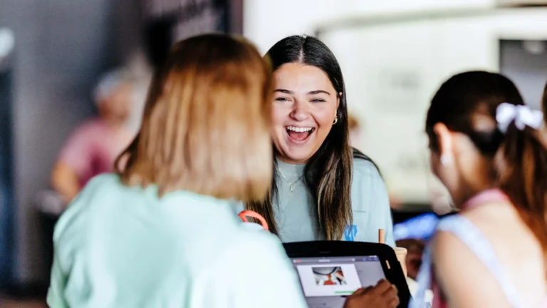Smiling student checking in at TBC Student Midweek in Lake Charles.