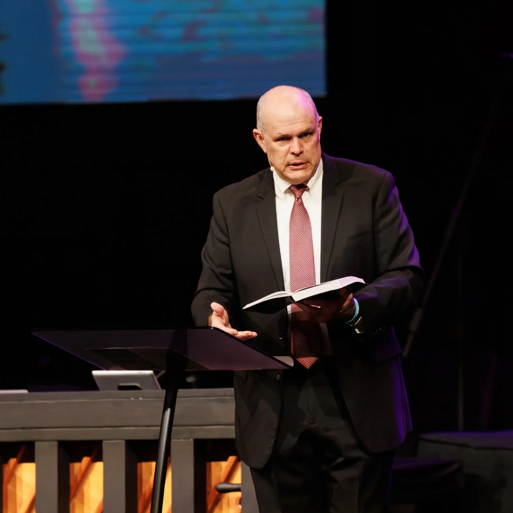 Pastor David Rose holding a Bible while preaching on hope at Trinity Baptist Church.