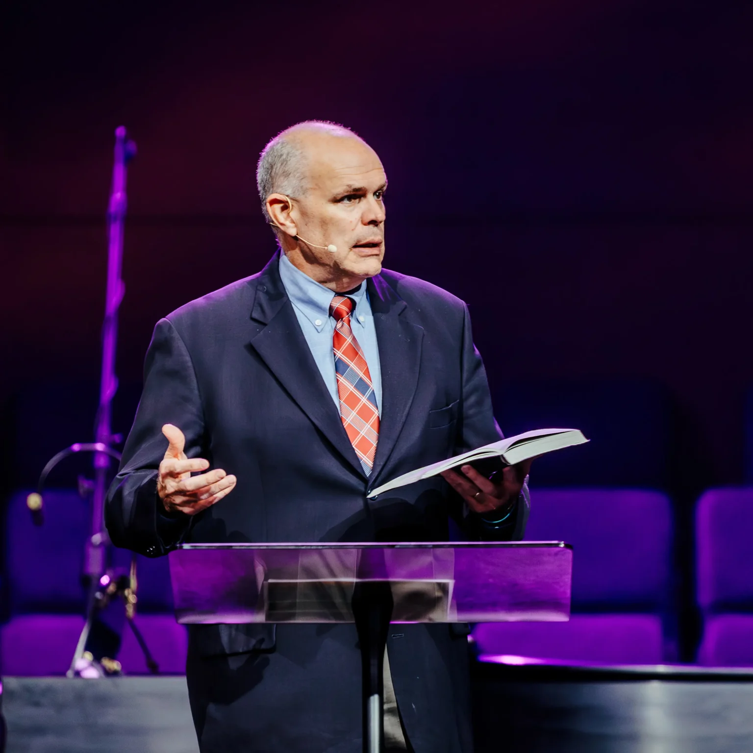 Pastor David Rose speaking with open Bible during sermon on corruption and marriage.