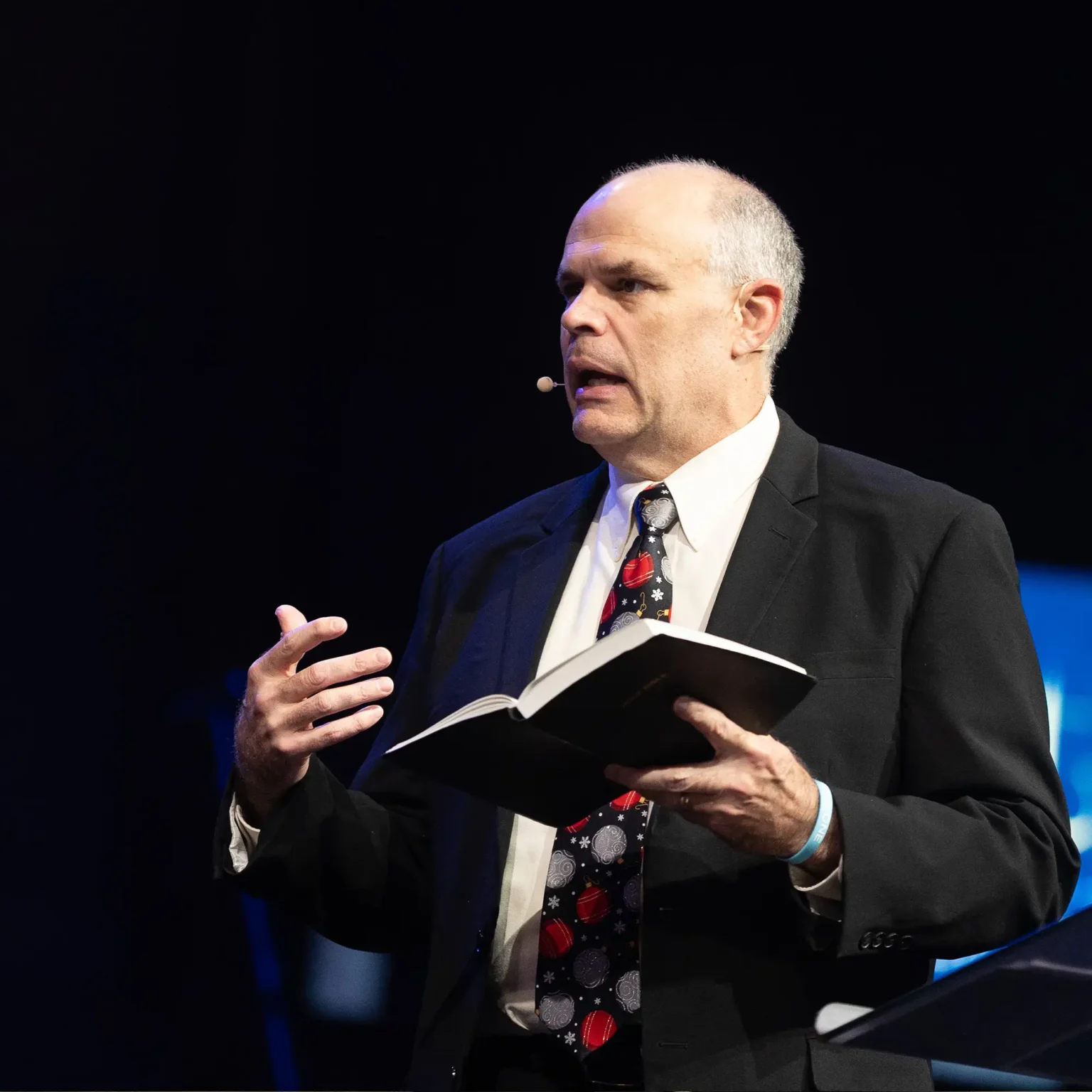 Pastor David Rose preaching at Trinity Baptist Church with an open Bible.