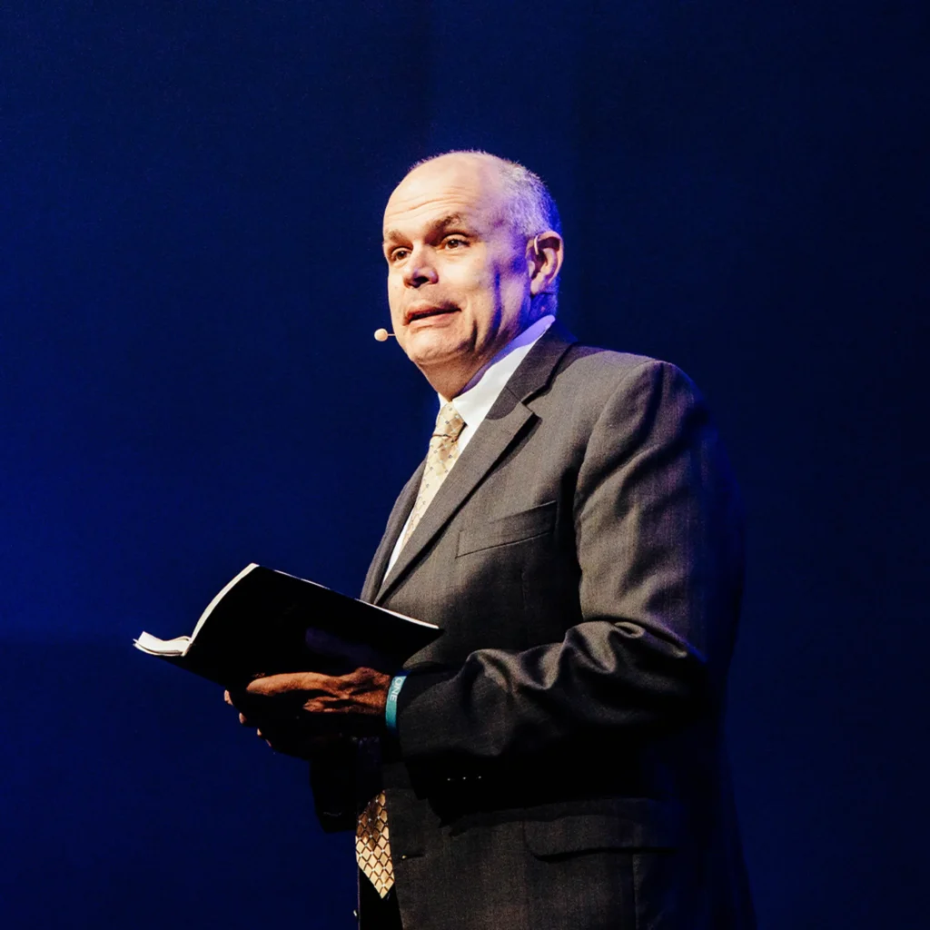 Pastor David Rose preaching open Bible in hand at Trinity Baptist Church — Staying the Course sermon.