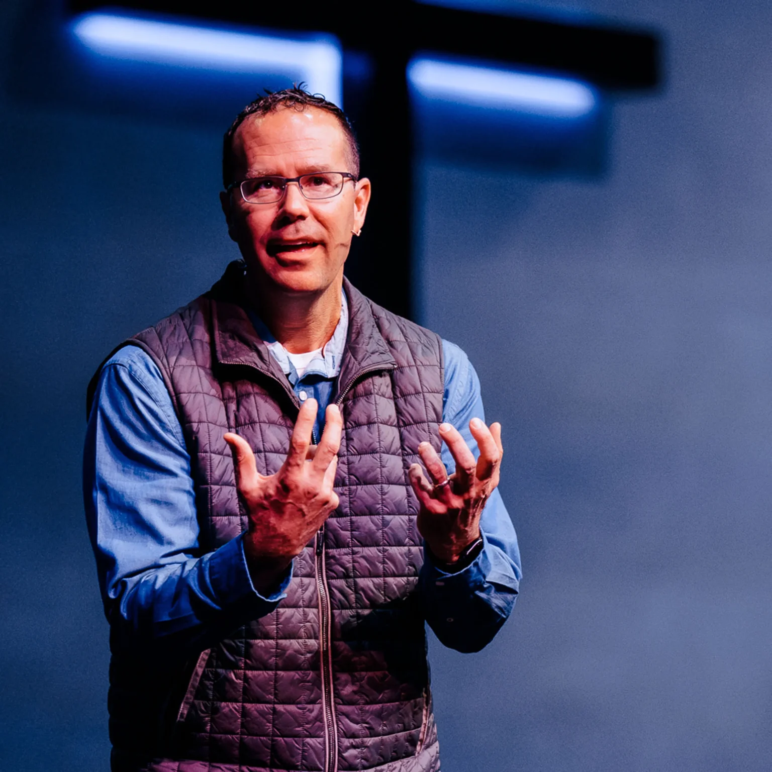 Pastor Ashley Austin speaking at Trinity Baptist Church with illuminated cross in background — Seven Spiritual Practices sermon